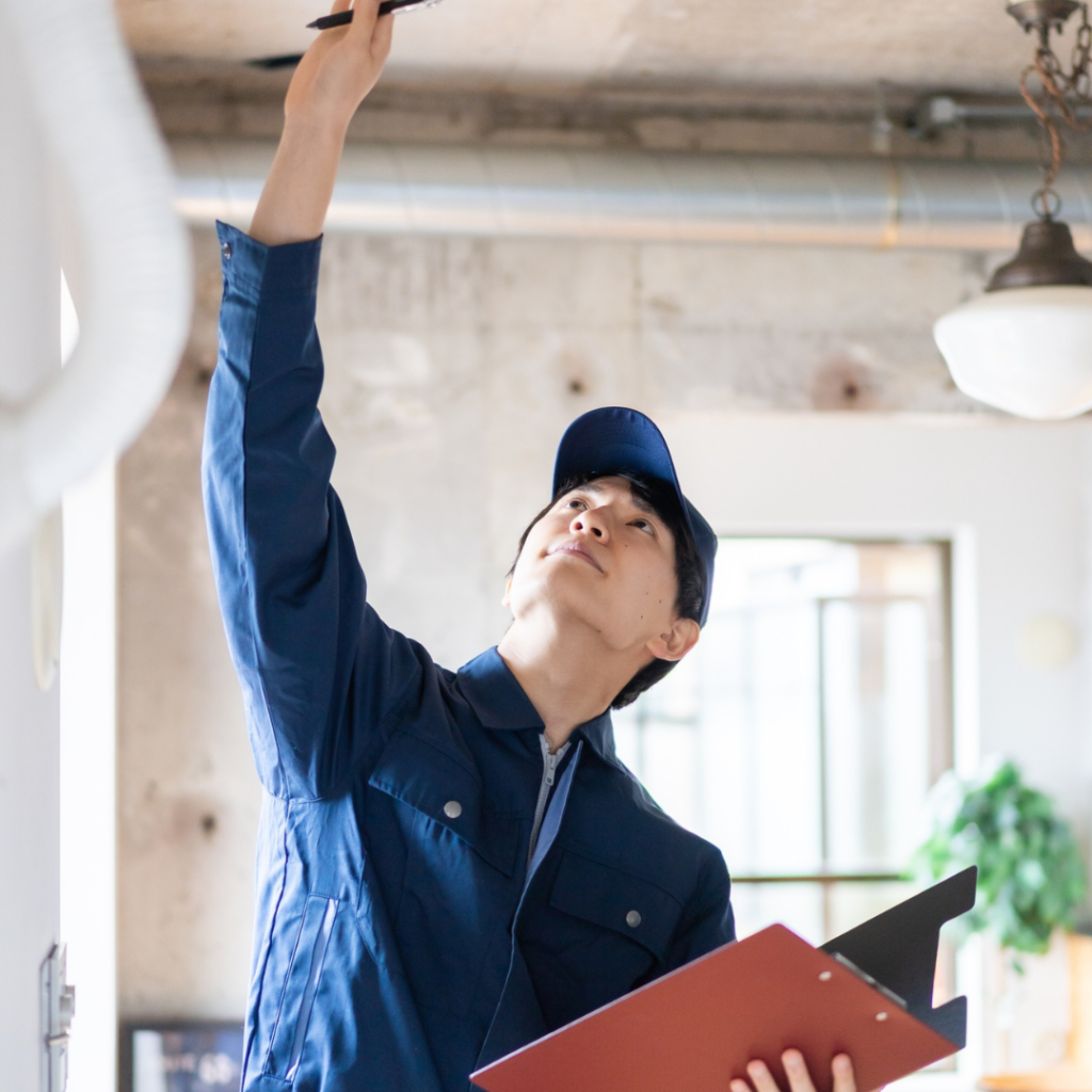 A home inspector carrying a binder and carrying out his inspection.