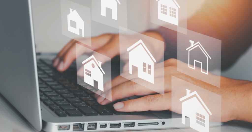 A person typing on the computer with home icons hovering over the computer.