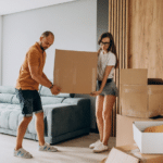 Young couple moving a box together in the living room.