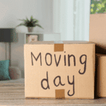 A box in the living room with the words "Moving day" written on the front.